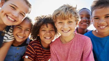 iStock Smiling Kids Close up of pre-teen friends in a park smiling to camera