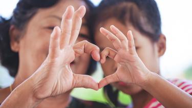 iStock Image - Heart Hands grandmother and little child girl making heart shape with hands together with love