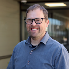 Brian Davies - HR Manager Male wearing glasses and blue shirt smiles for photo
